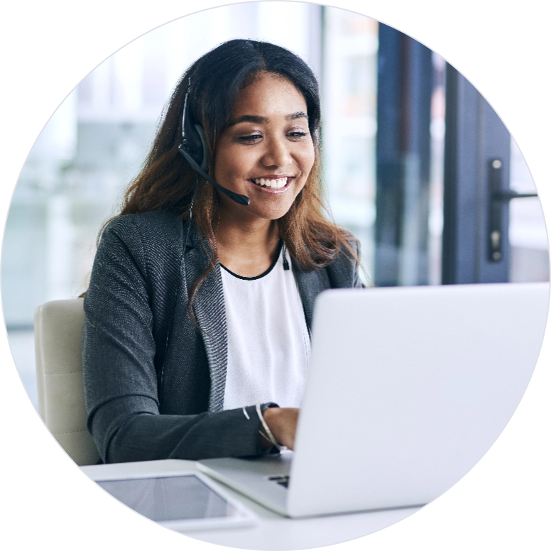 Front view of a woman working on her laptop and wearing a headset